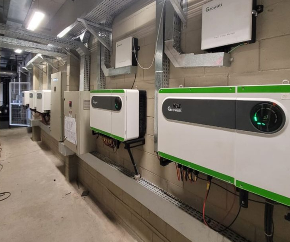 Row of wall-mounted industrial inverters in an electrical room